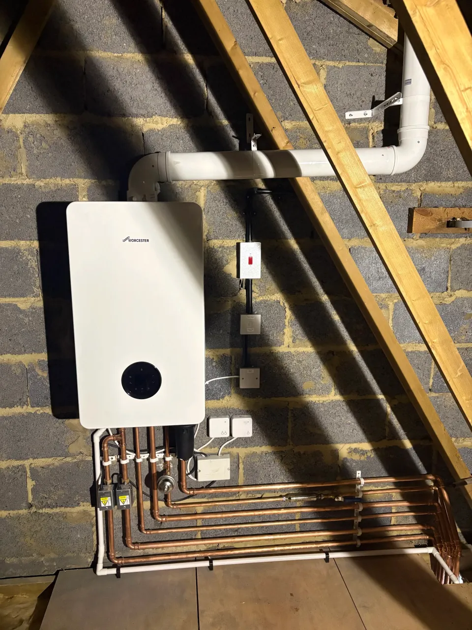 Worcester boiler installed between loft rafters with copper pipework